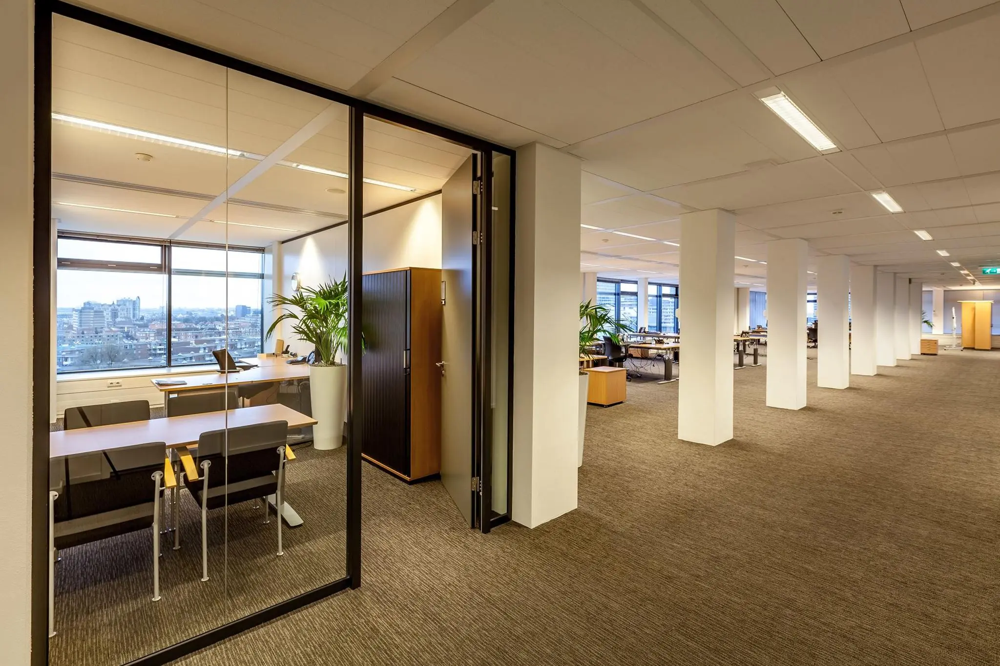 Modern kantoorpand aan de Prinses Beatrixlaan met glazen vergaderruimte en open werkplekken.